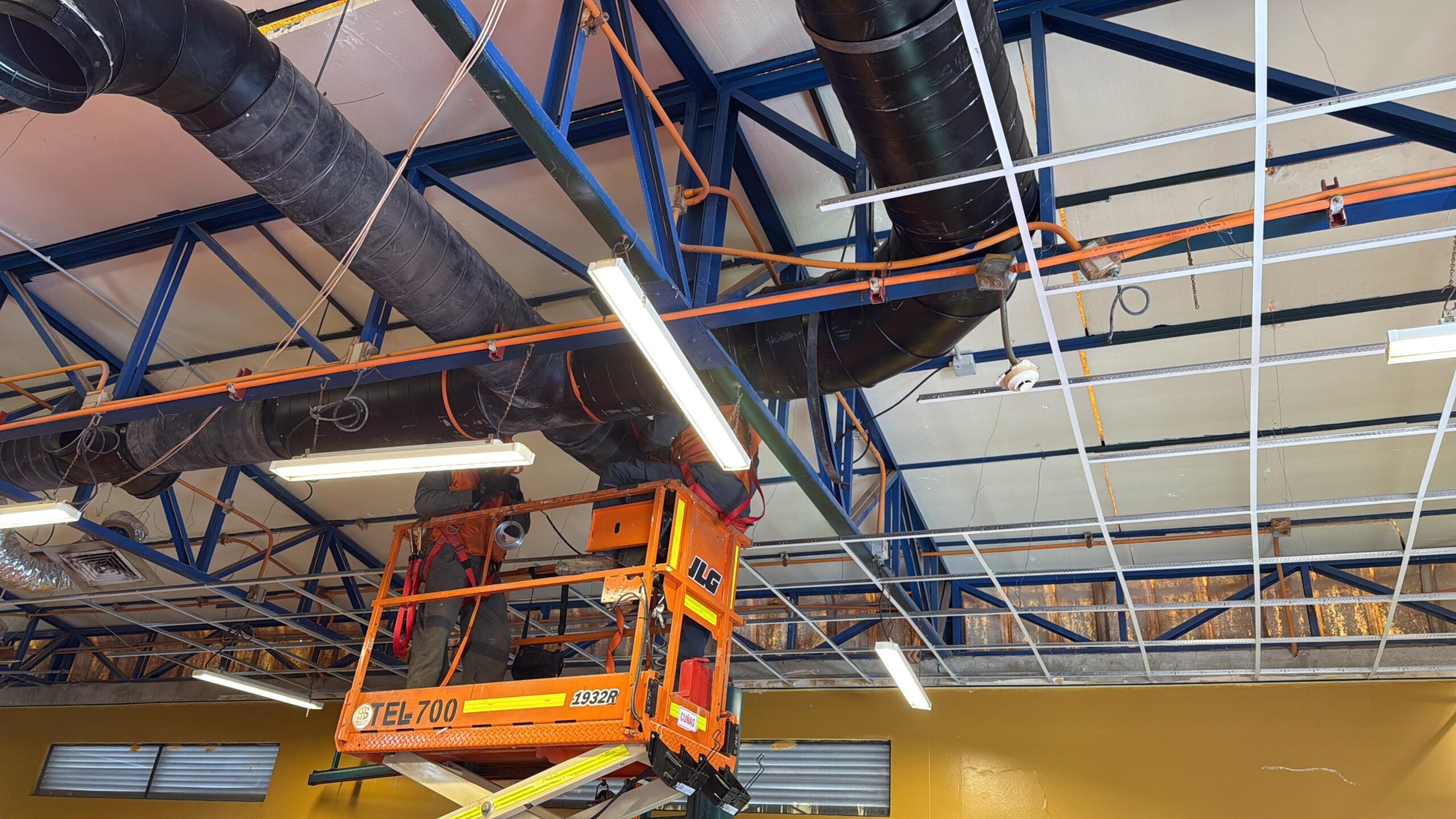 Instalación de ductos de ventilación en estructura de techo industrial